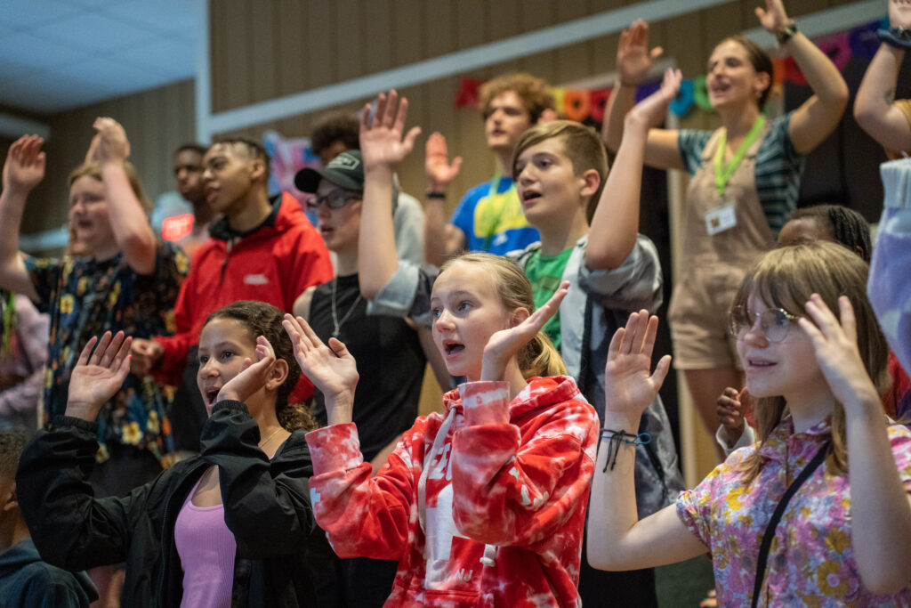 Campers sing and do motions during summer Camp worship.